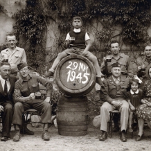 Foto z 29. května 1945 - Na sudu Ferdinand Jiskra, vlevo dole tatínek Ferdinand, vpravo dole maminka Marie, vedle sedící holčička Marie Kolářová-Jiskrová, vedle sedící kapitán Müllner. Archiv rodiny Jiskrových.
